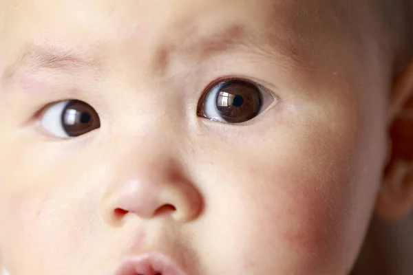 Die Gesichtszüge eines Babys; ein merkwürdiger Ausdruck — Stockfoto