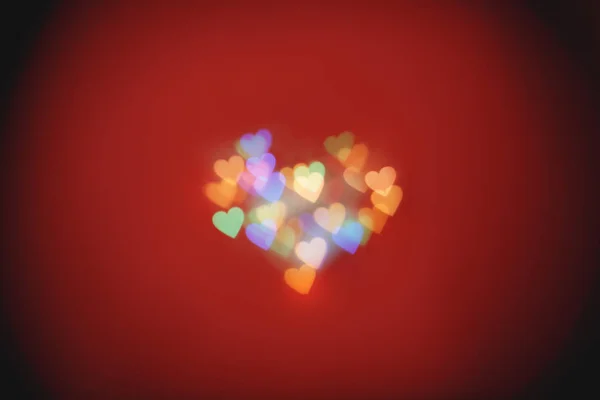 Talrijke hartvormige vlekken op de rode achtergrond — Stockfoto