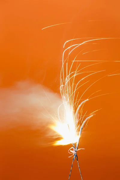 Two burning fireworks in the orange background — Stock Photo, Image