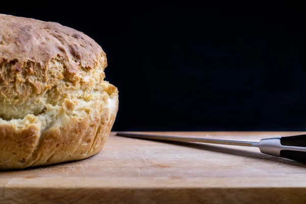 Hembakat bröd på skrivbord med kniv — Stockfoto
