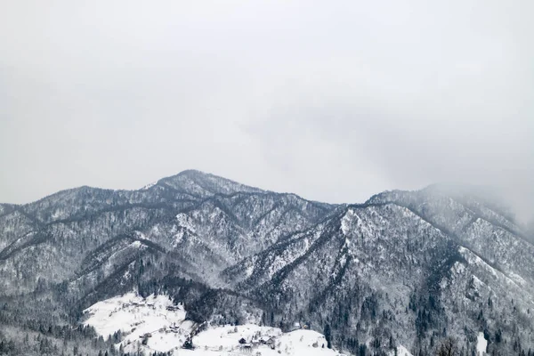 Bergen in de mist, bedekt met sneeuw — Stockfoto