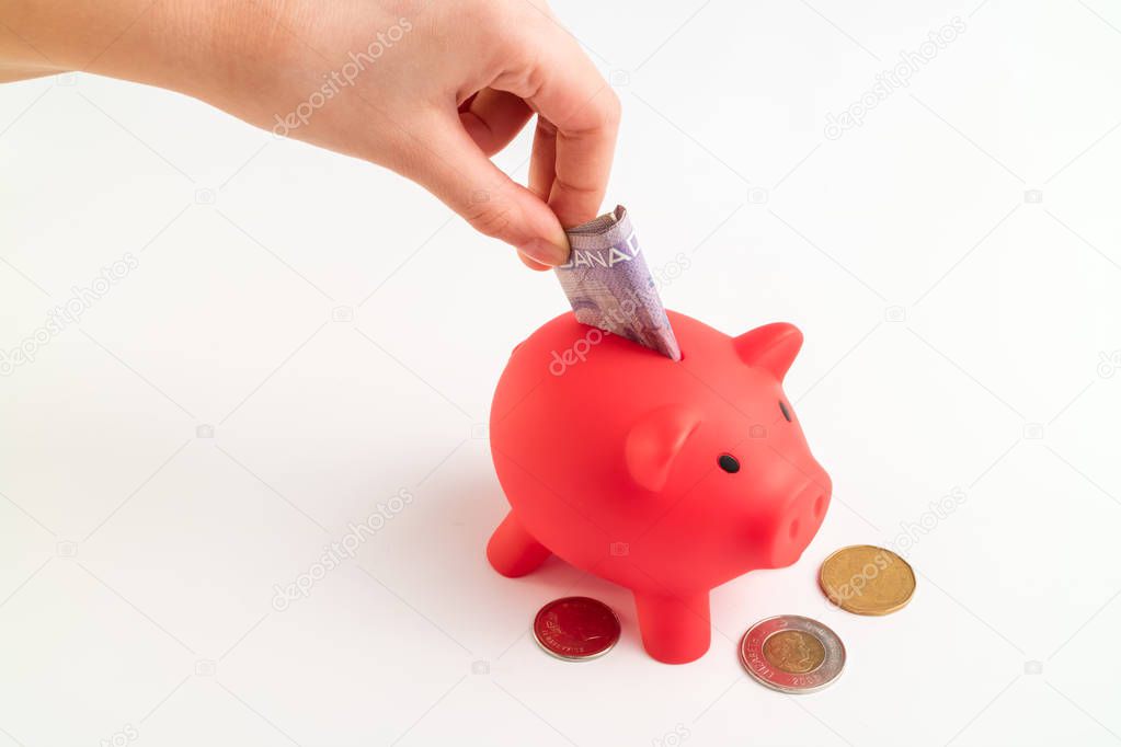 Red Piggy Bank filled with Canadian Dollars