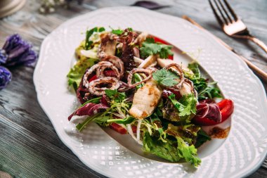 Salata, beyaz balık, kızarmış soğan halkaları sosu.