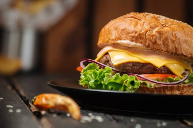 Koyu ahşap arka planda klasik çizburger.