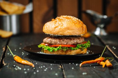 Koyu ahşap arka planda hakiki klasik hamburger.