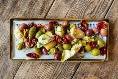 Şarap aperatifleri zeytin, enginar ve domates.