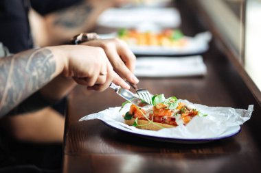 Erkek elleri somonla tost yiyor.