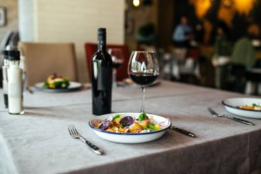 Restoran yemeği masada kırmızı şarapla servis edilir.