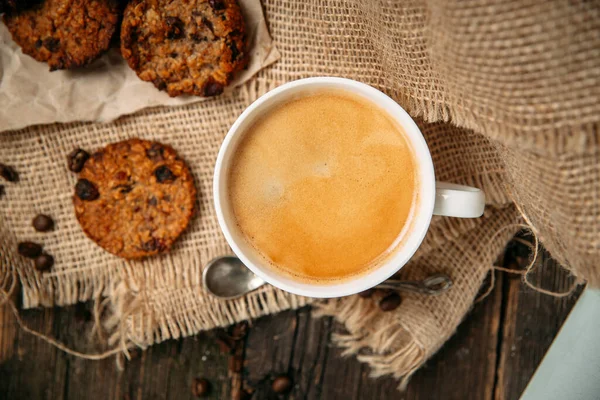 Top melihat kopi dengan cookie di atas meja kayu — Stok Foto