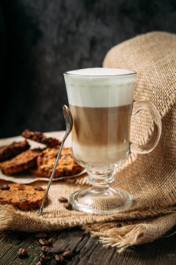 Ahşap masada kurabiyeli Latte Macchiato.