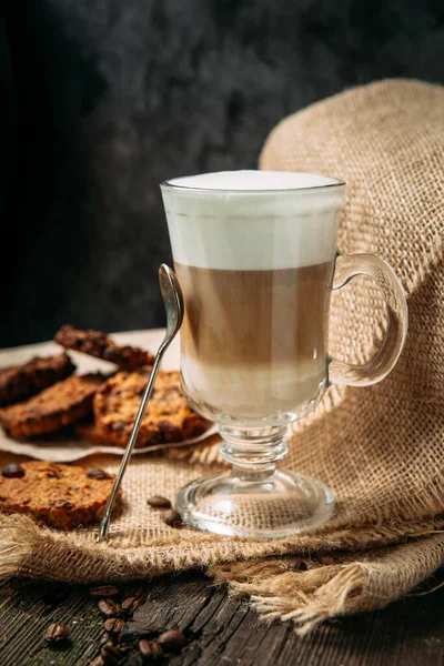 Latte Macchiato z ciasteczkami na drewnianym stole — Zdjęcie stockowe