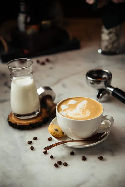 Café capuchino para el desayuno con leche y galletas en una mesa de mármol blanco — Foto de Stock