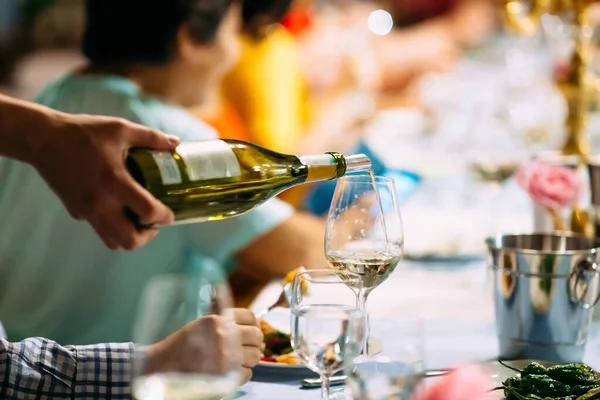 Mano di cameriere versando vino in un tavolo servito di vetro — Foto Stock