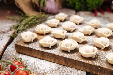 Tahta üzerinde yarı bitmiş pelmeni köftesi.