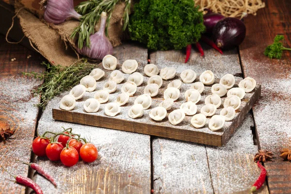 Tahta üzerinde yarı bitmiş pelmeni köftesi.
