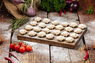 Tahta üzerinde yarı bitmiş pelmeni köftesi.