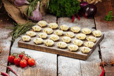 Tahta üzerinde yarı bitmiş pelmeni köftesi.