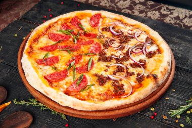 Tahta masada sosisli ve soğanlı pizza.