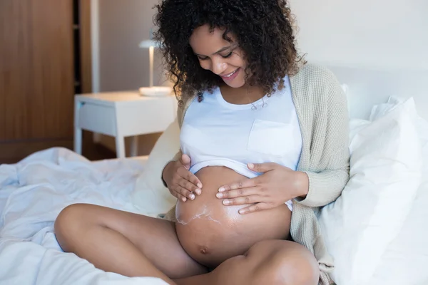 Hamile kadın nemlendirici göbek — Stok fotoğraf