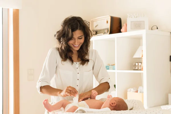 Mother changing baby's diaper — Stock Photo, Image