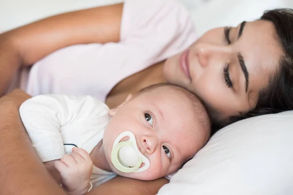 Mamma med bebis i sängen — Stockfoto
