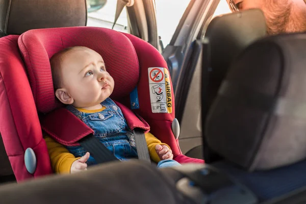 Vater schnallt sein Baby im Autositz an — Stockfoto