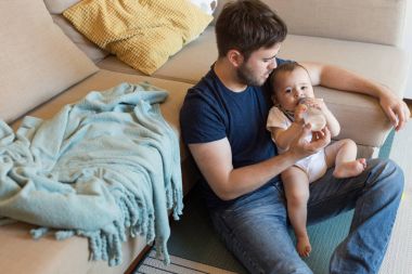 Baba bebeği besliyor