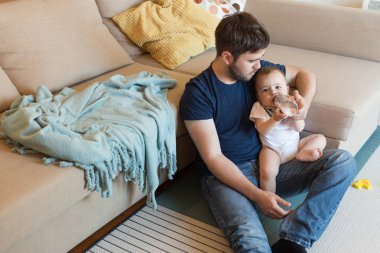 Baba bebeği besliyor