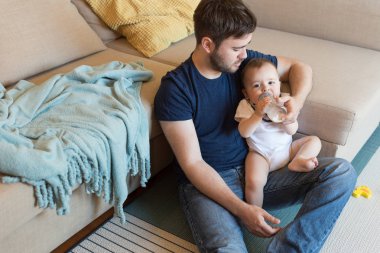 Baba bebeği besliyor