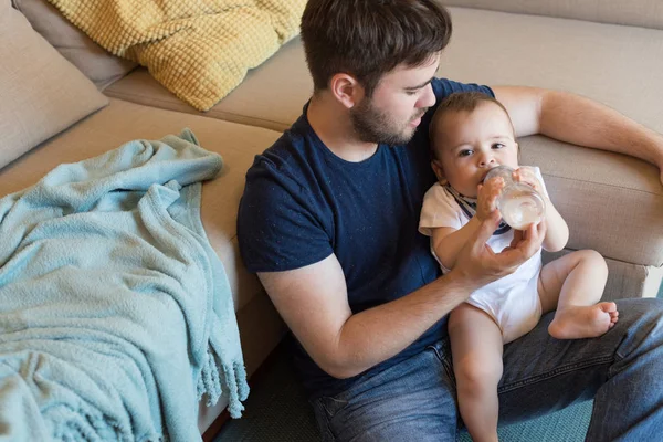 Baba bebeği besliyor