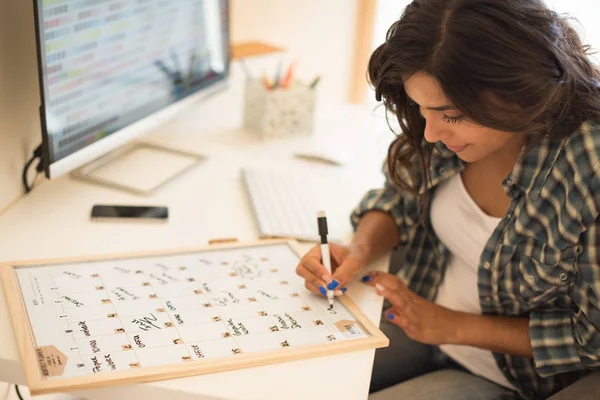 Woman writing on calendar — Stock Photo, Image