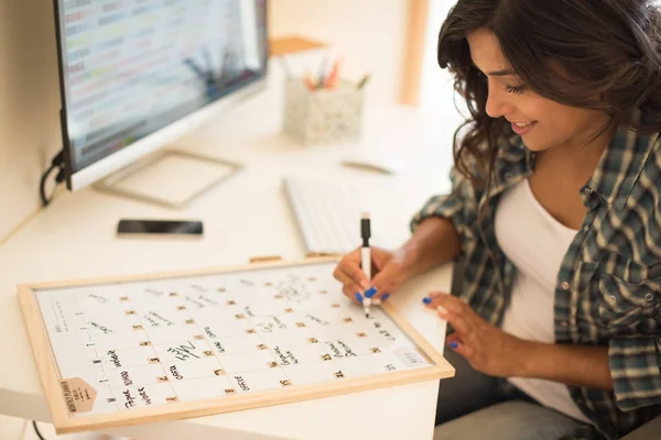 Frau schreibt auf Kalender — Stockfoto