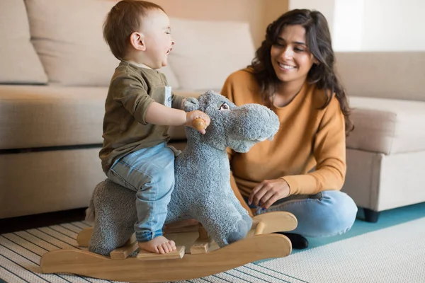 Bebé jugando con un caballo mecedora —  Fotos de Stock