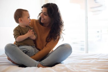 Anne evde bebeğiyle oynuyor.