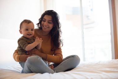 Anne evde bebeğiyle oynuyor.