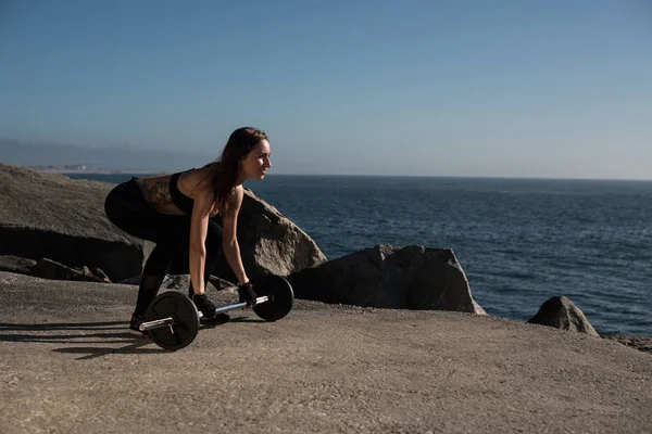 フィットの女性を持ち上げる重み - 屋外 — ストック写真