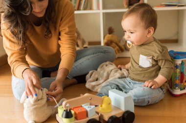 Evde yürümeye başlayan çocuk ile oynarken annesi 
