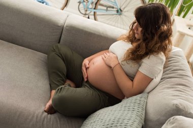 Hamile kadın karnına dokunuyor.