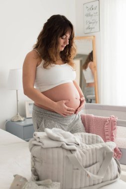 Hamile kadın karnına dokunuyor.