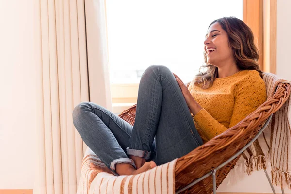 Optimistische Vrouw Zittend Een Comfortabele Rotan Stoel Thuis — Stockfoto