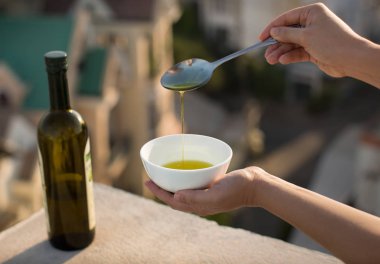Olive oil over an Italian city background clipart