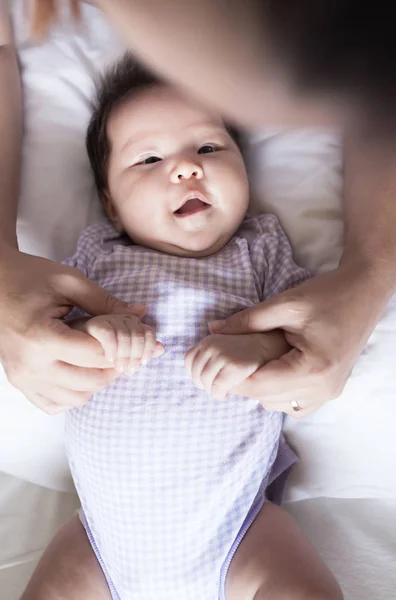 Ein glückliches Baby, das zu seinem Elternteil aufblickt, während der Elternteil das Baby liebevoll hält. — Stockfoto