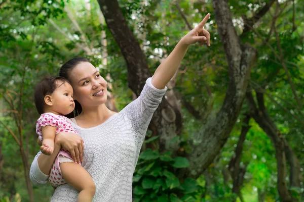 Mãe mostrando sua filha bebê os diferentes animais na natureza — Fotografia de Stock