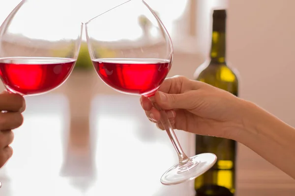 Celebrating by clinking glasses of red wine — Stock Photo, Image