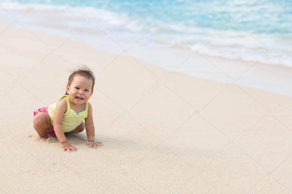 Cute baby playing  on a beautiful sandy beach