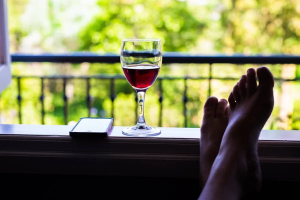 Relaxed person sitting back with wine — Stock Photo, Image