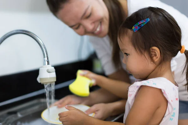 母親と娘が一緒に家で皿を洗う — ストック写真