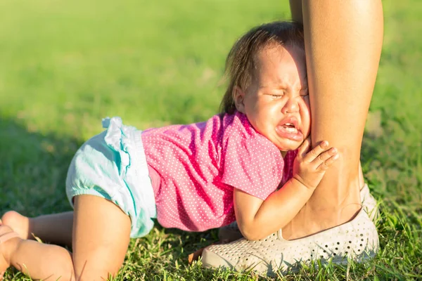 Dziecko Leżące Ziemi Próbujące Utrzymać Nogi Matki Zdesperowane Zwrócić Siebie — Zdjęcie stockowe