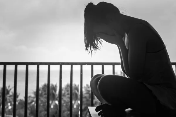 一个女人独自坐在旅馆的阳台上哭泣 蒙着脸 黑白相间 — 图库照片