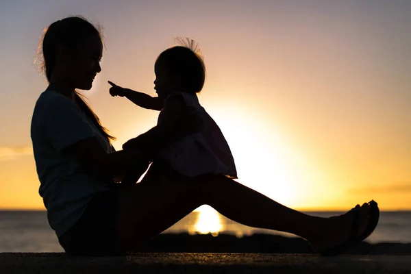 Bebek Annesinin Kucağında Turuncu Bir Günbatımı Arka Planıyla Oturuyor Siluet — Stok fotoğraf